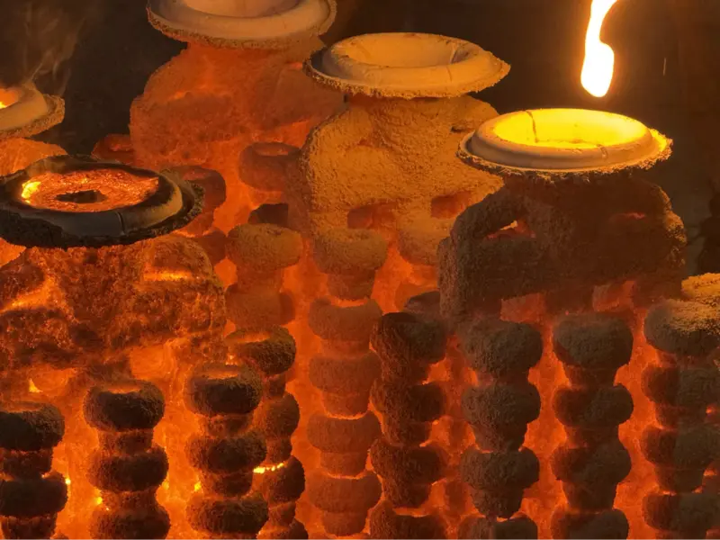 Molten metal being poured into ceramic shell moulds during investment casting