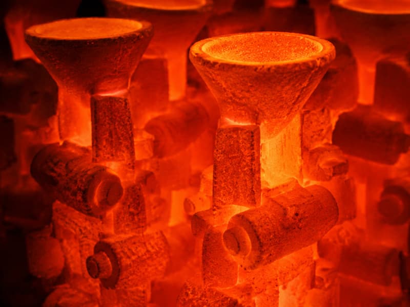 Ceramic shell moulds glowing orange inside the firing furnace