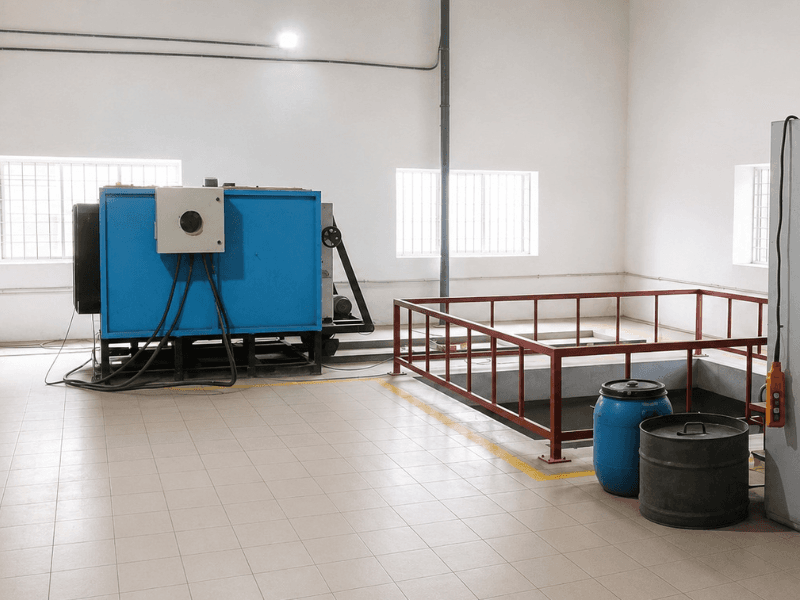 Heat treatment furnace beside a guard-railed quench pit in Precimetal's treatment bay
